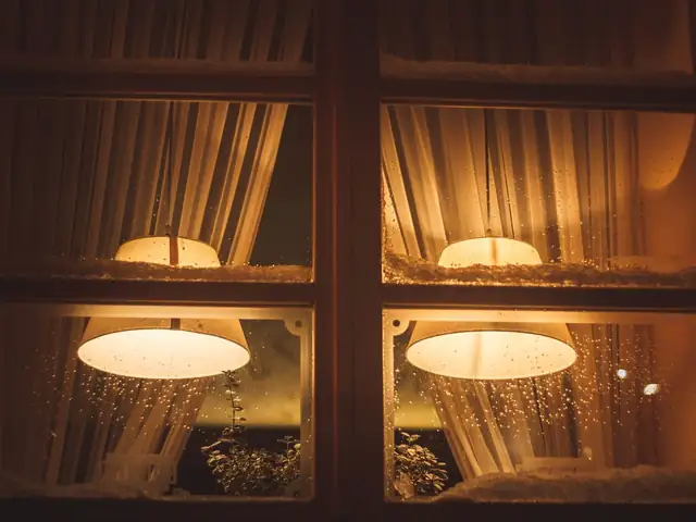 Warm lights glowing in the windows of a home on a winter evening