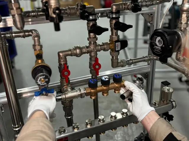 Technician installing copper pipes and valves on a new heating system
